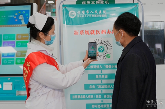導診員指導患者掃就醫(yī)碼“一碼通”（攝影：陳影）.jpg